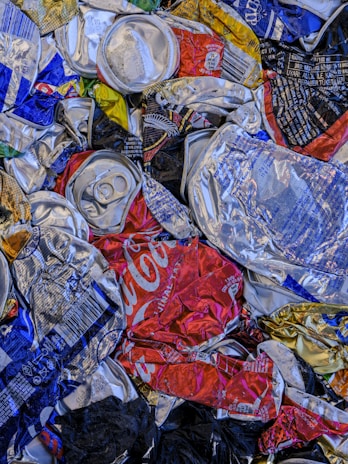 A pile of soda cans and cans of soda