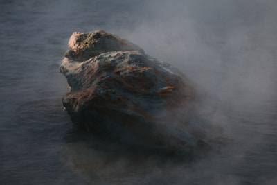A rock in the middle of a body of water