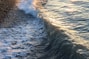 A wave is coming towards the shore of a beach
