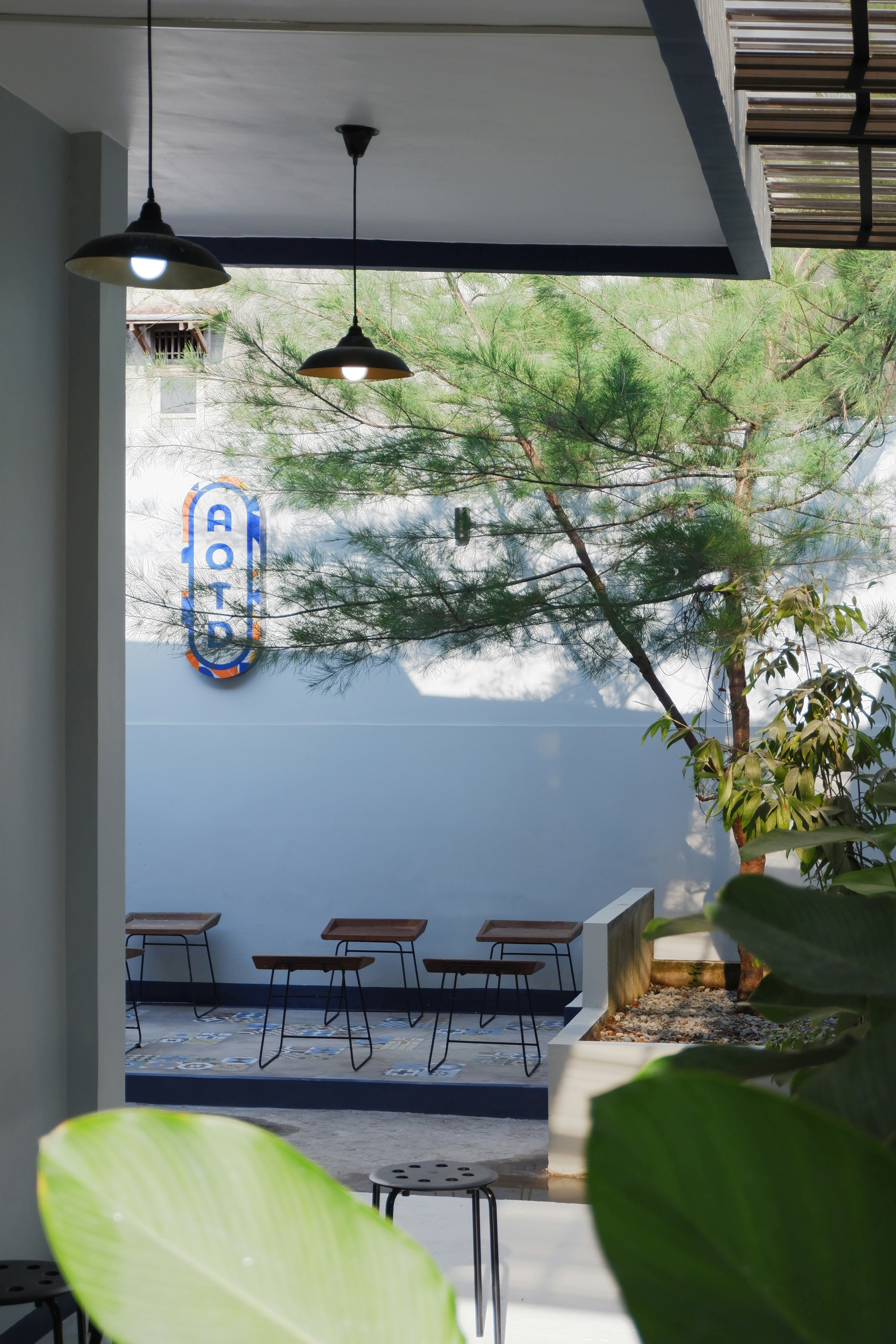 A patio with a table and chairs next to a tree