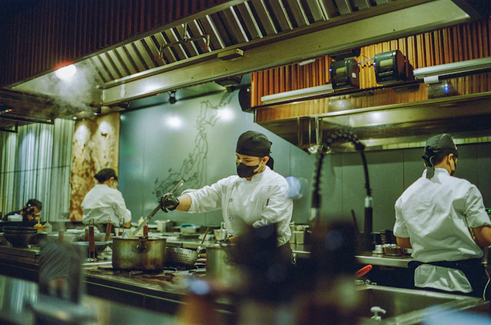 A kitchen line of cooks working the pass during service