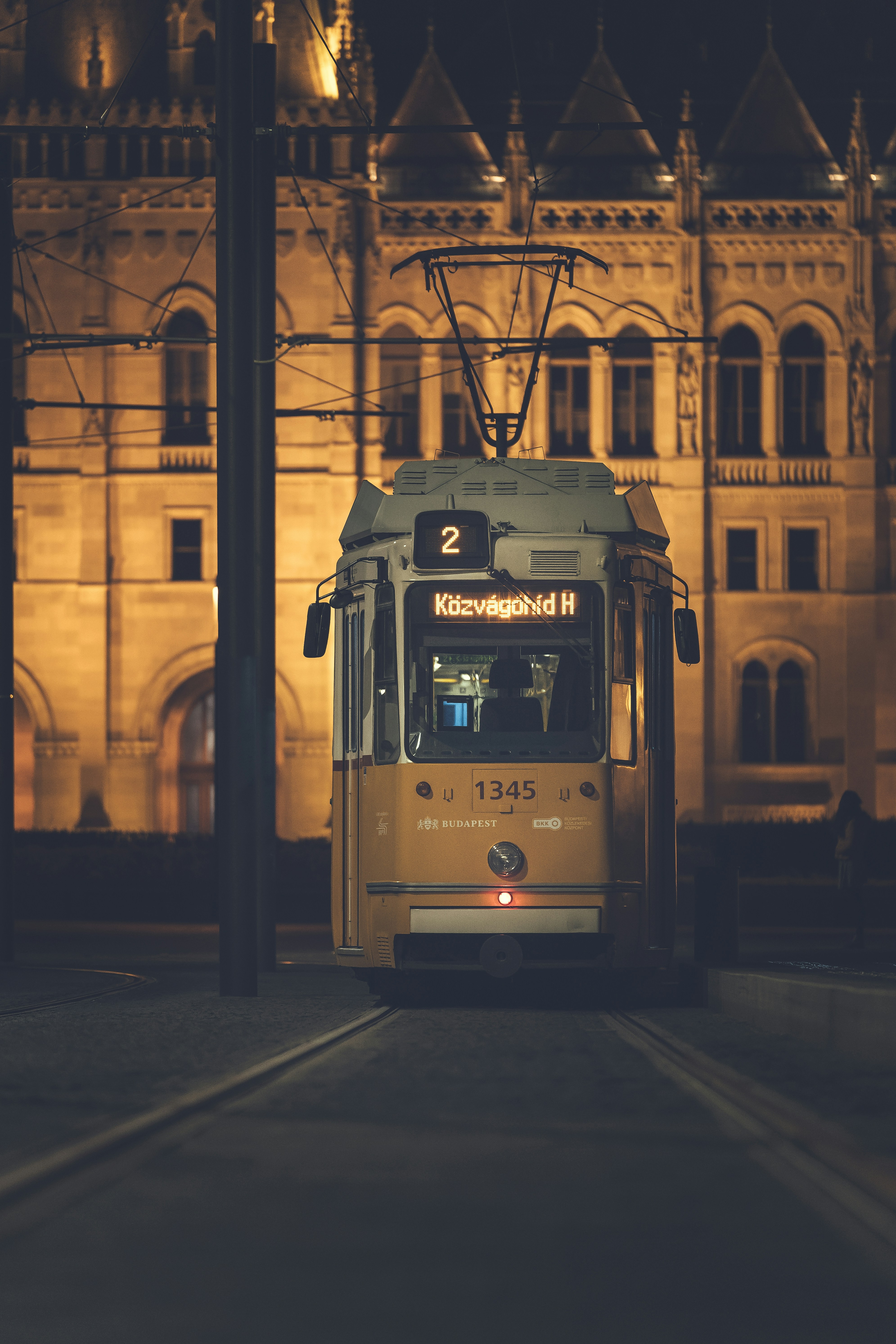 A city bus driving down a street next to a tall building
