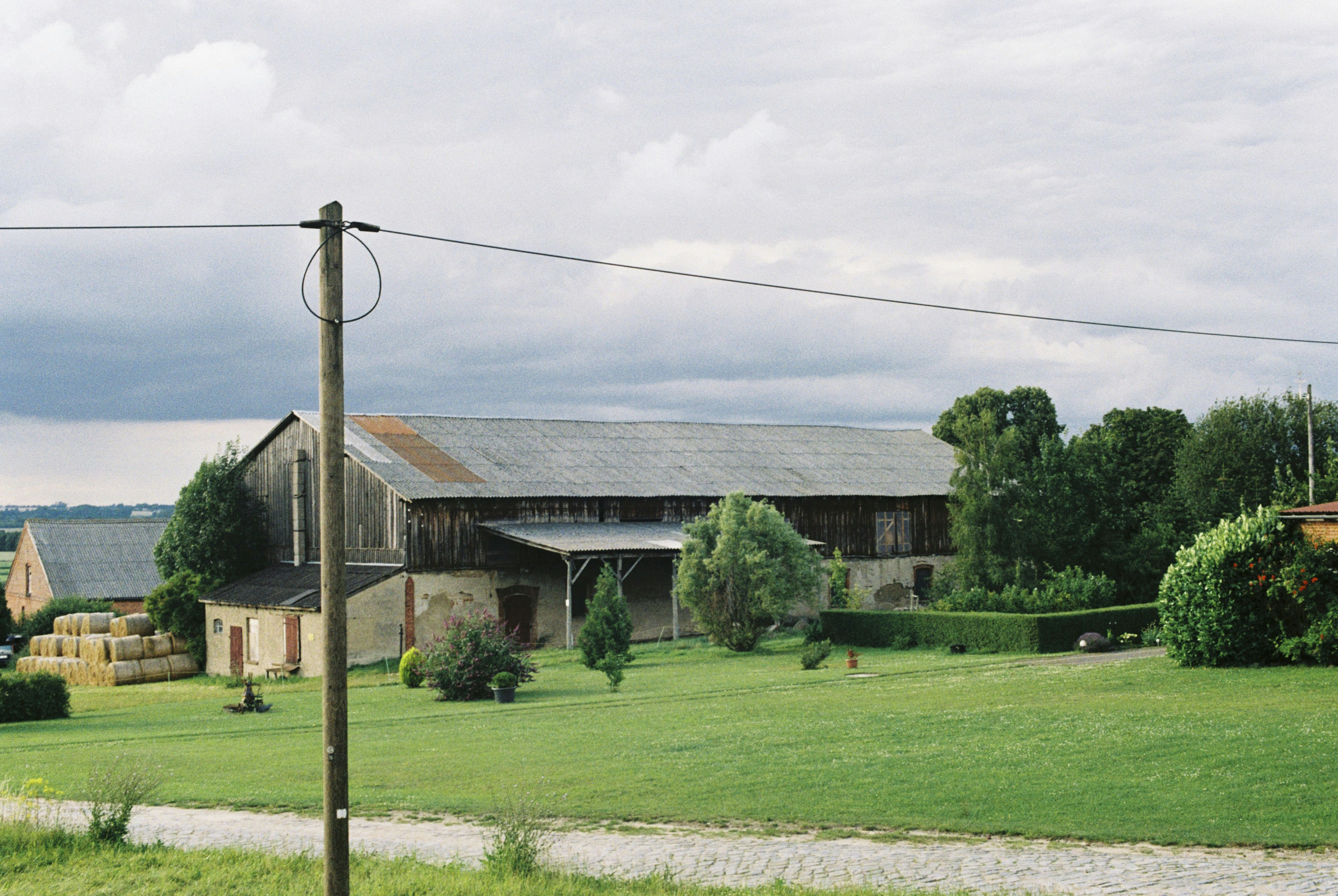 A field with a house and a barn in the background