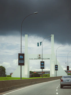 A car driving down a highway under a cloudy sky