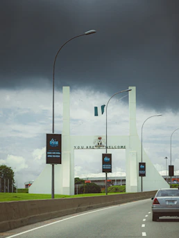 A car driving down a highway under a cloudy sky