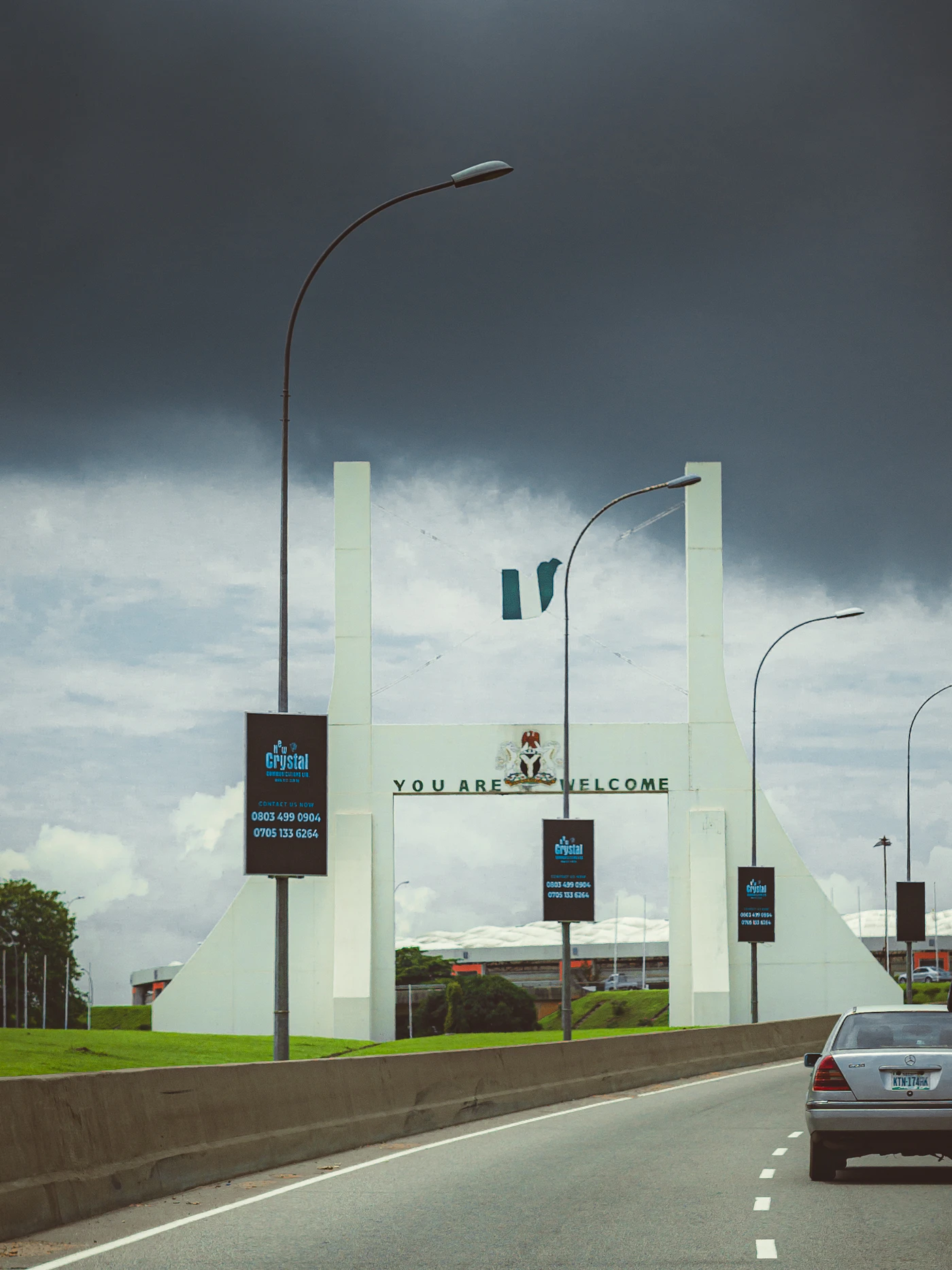 A car driving down a long highway under a cloudy sky
