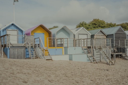A row of beach huts sitting on top of a sandy beach
