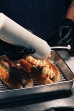 A person is using a machine to make hot dogs