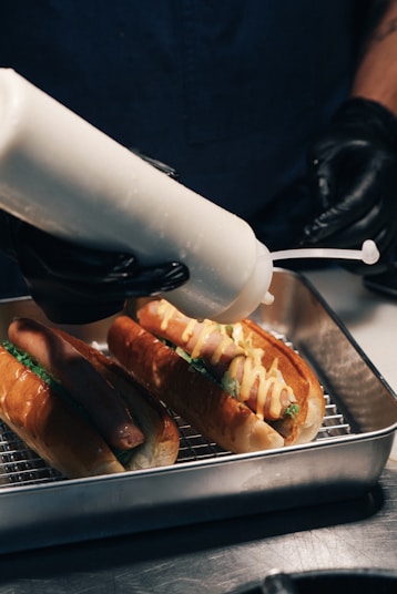 A person is using a machine to make hot dogs