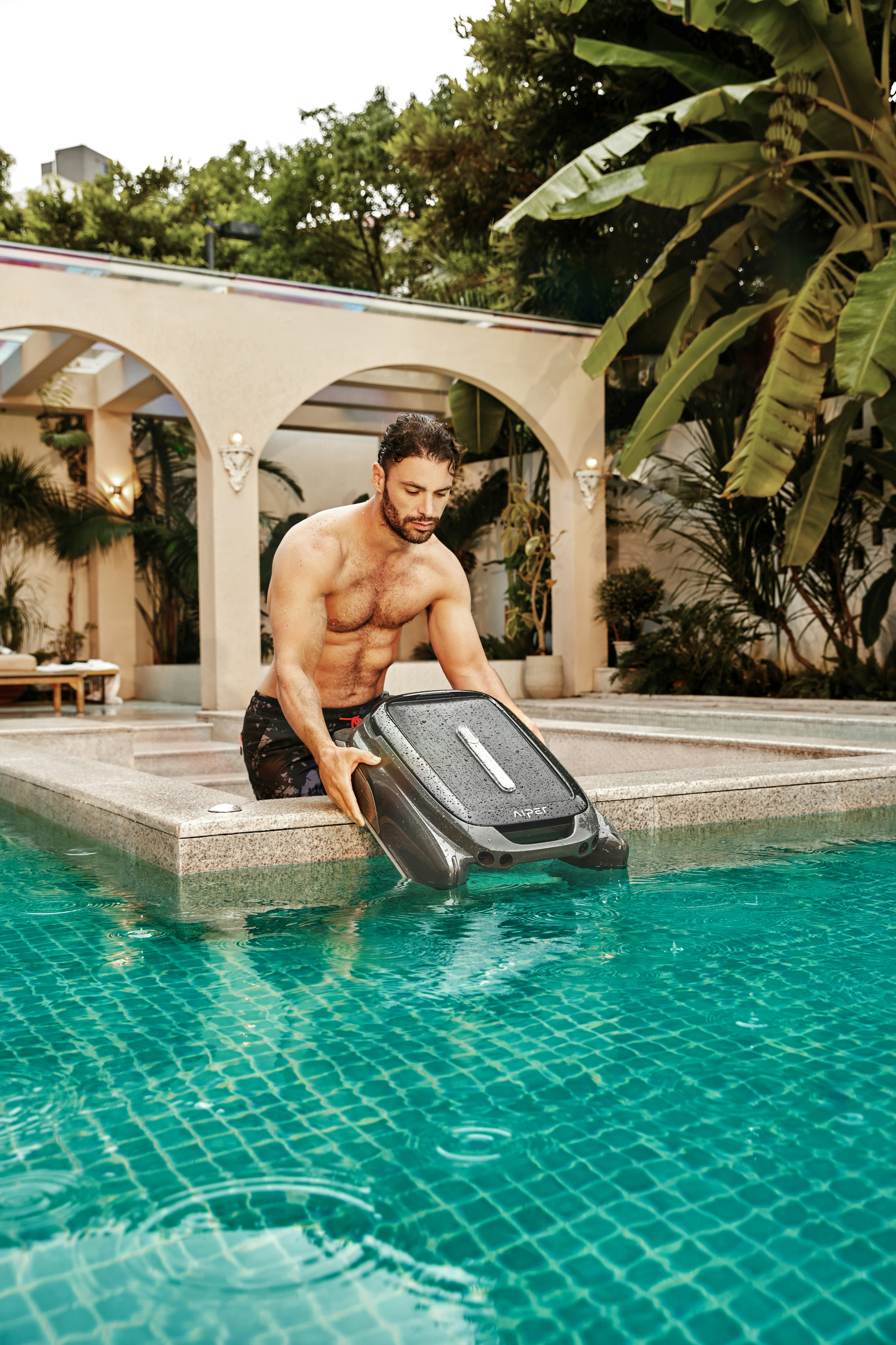 A man with a suitcase by a swimming pool