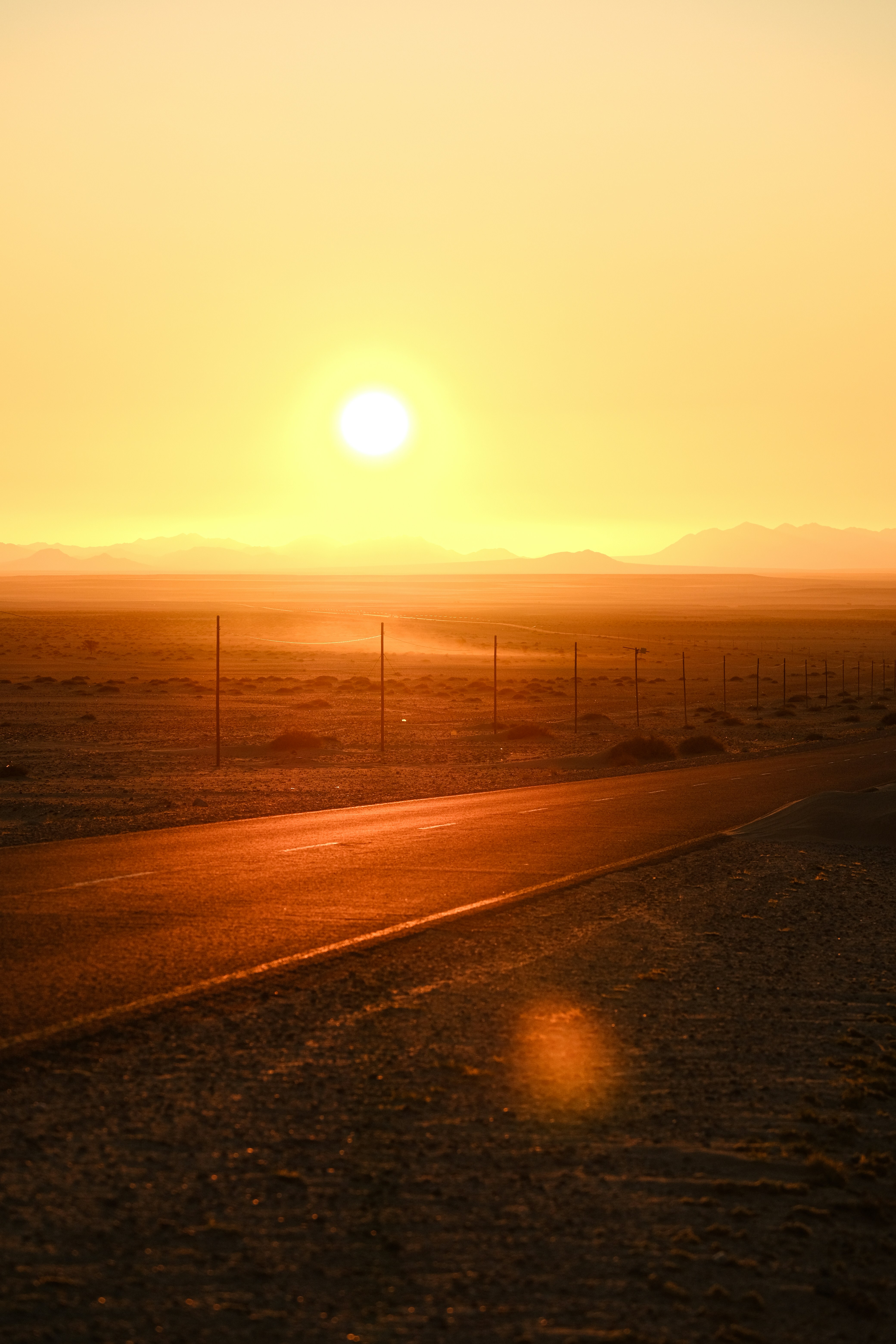 The sun is setting over a road in the desert photo – Free Nature Image ...
