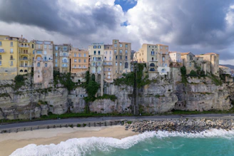 A view of a beach with buildings on the cliff