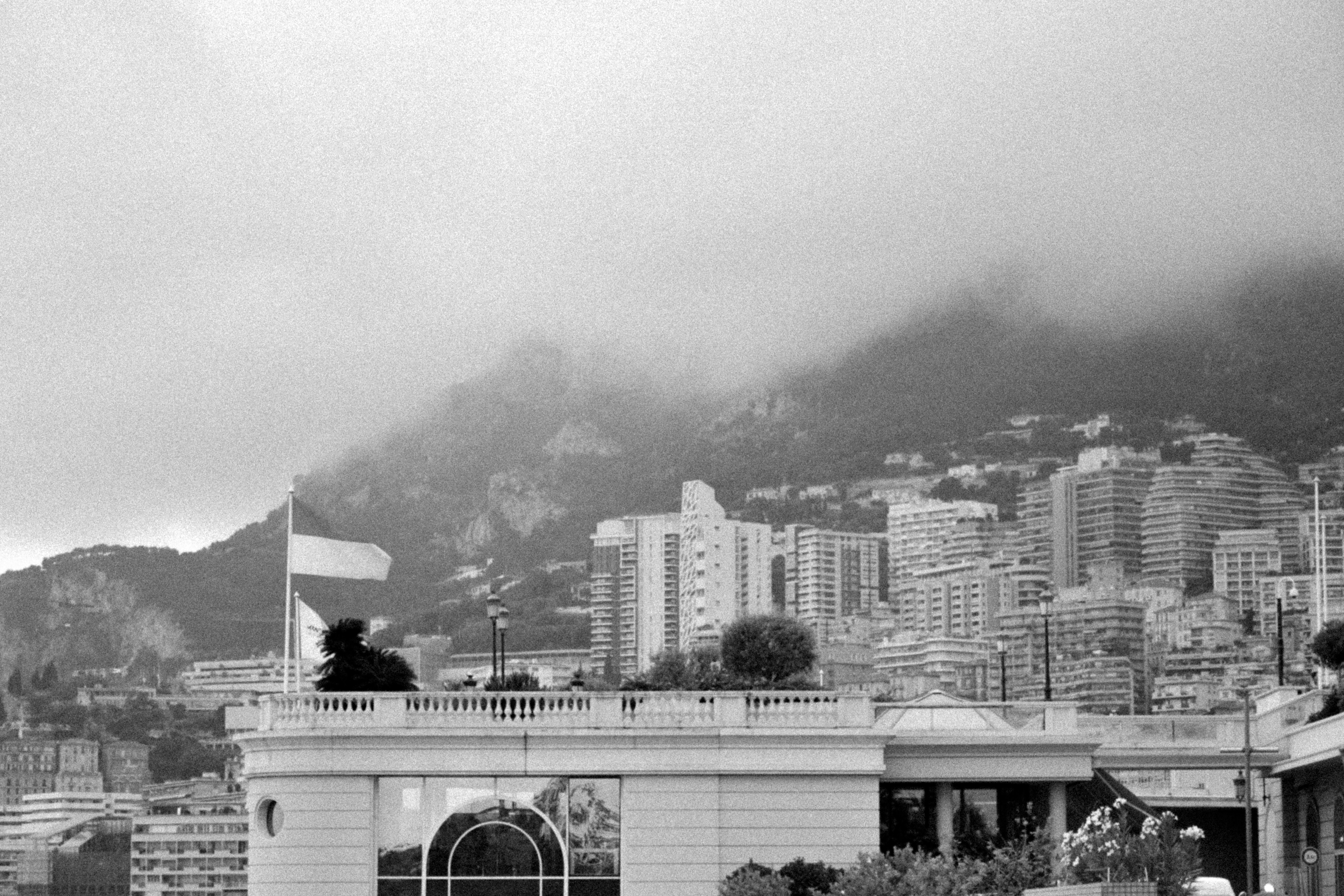 A black and white photo of a city with mountains in the background