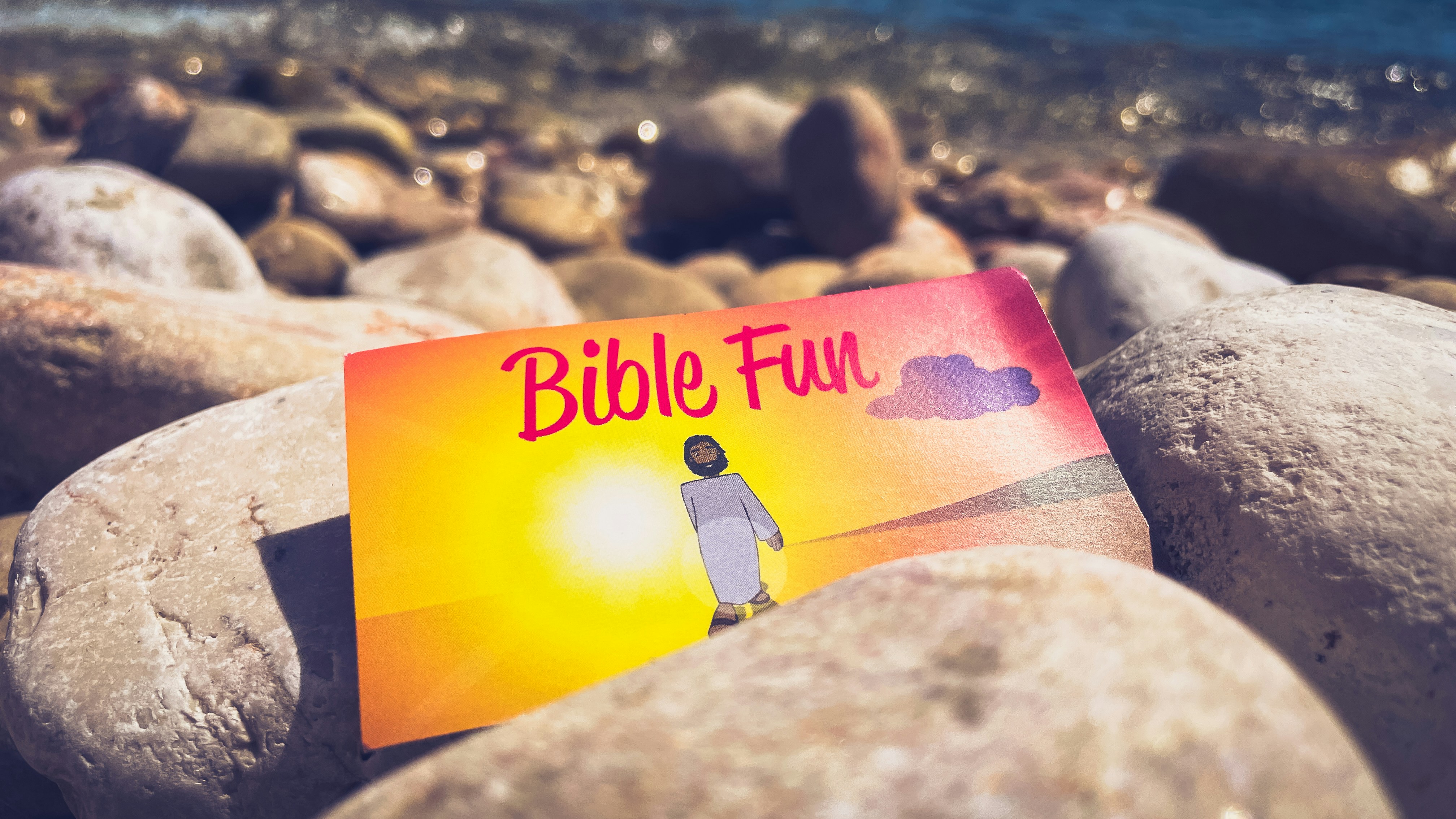 A bible book sitting on top of a pile of rocks