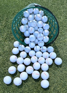 A green bucket filled with blue and white balls