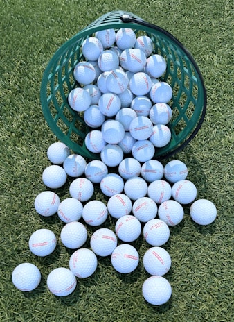 A green bucket filled with blue and white balls