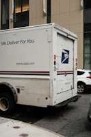 A mail truck parked in front of a building