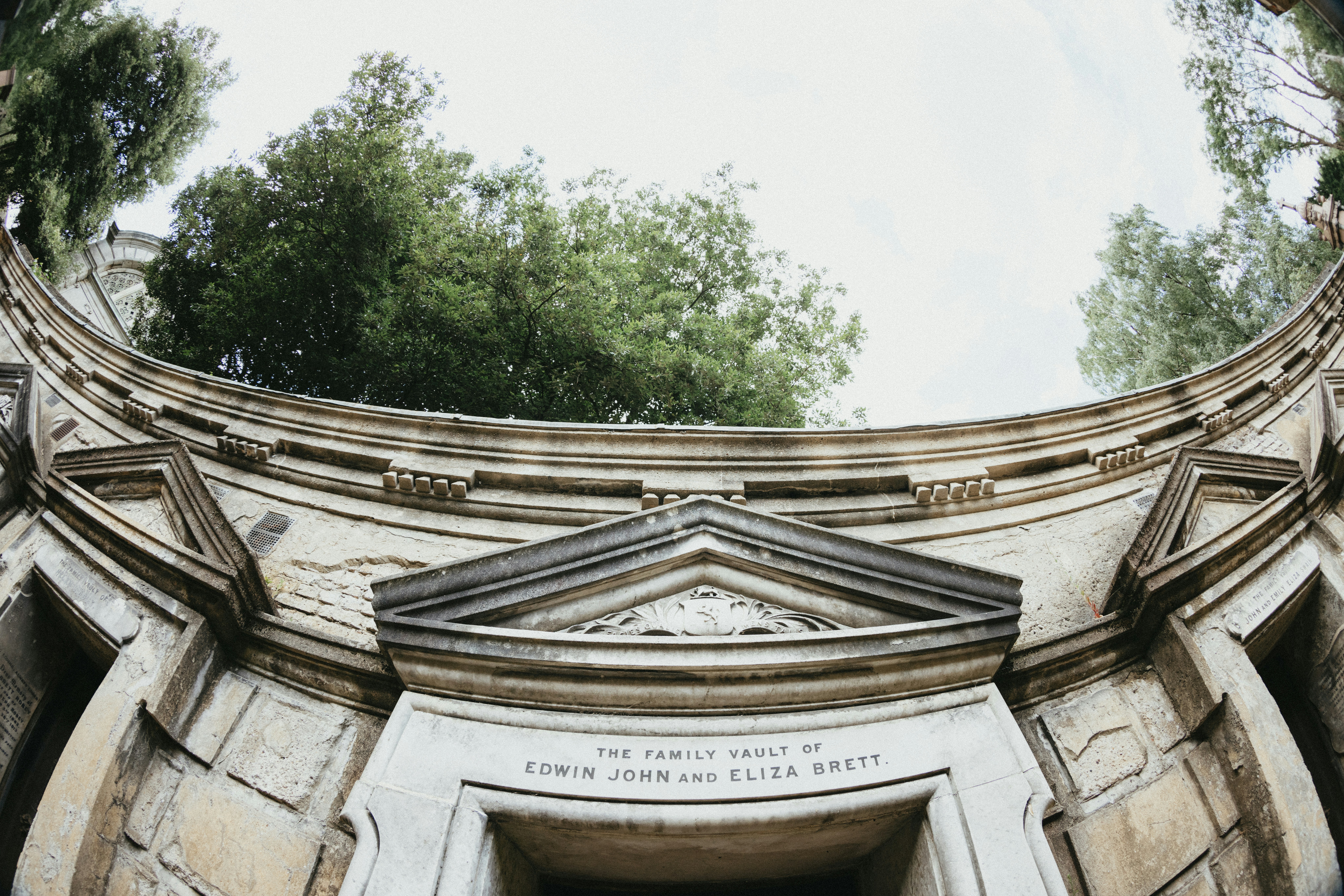 A circular picture of a building with trees in the background