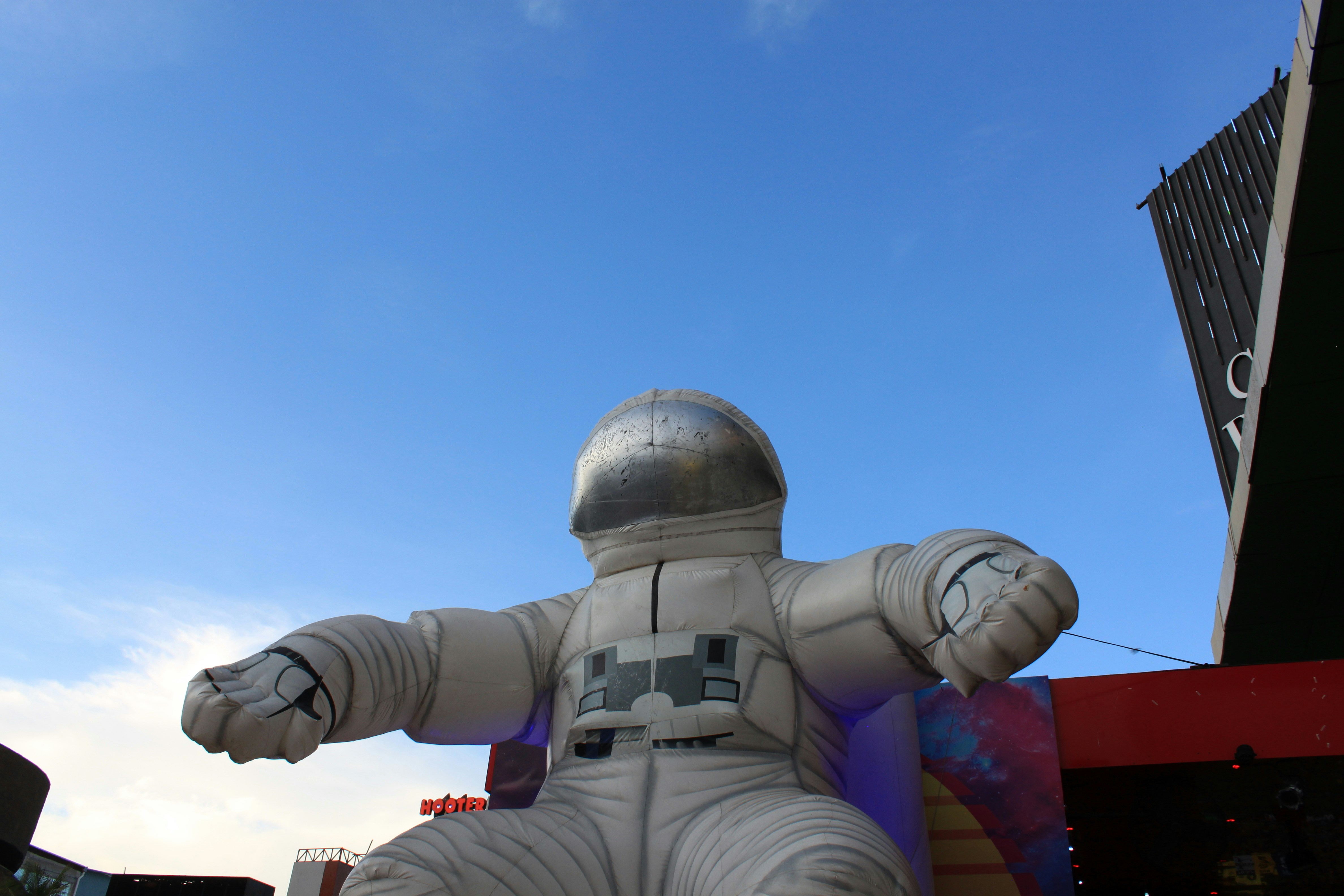 A large inflatable astronaut sitting on top of a building