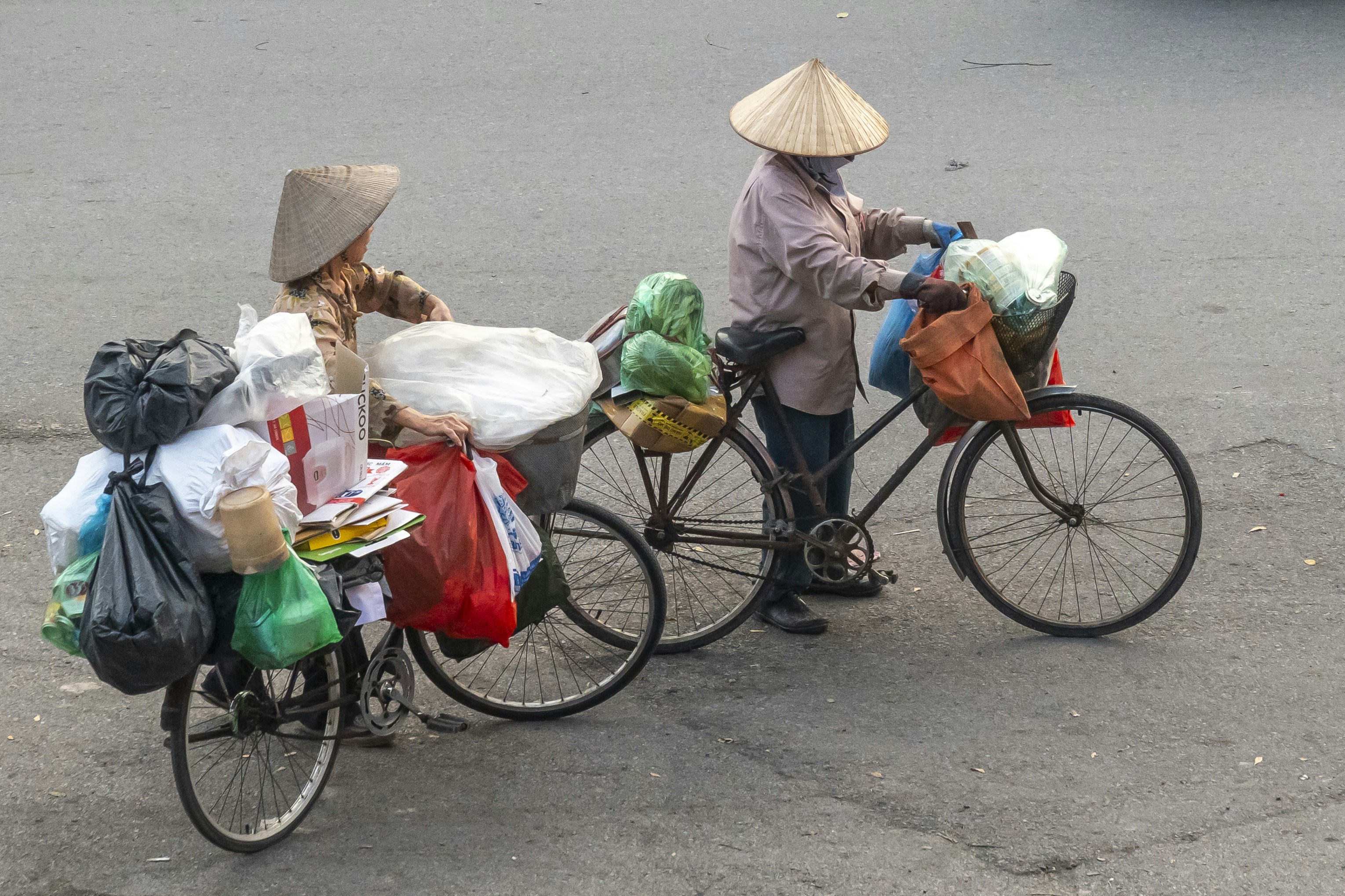 A couple of people riding bikes down a street
