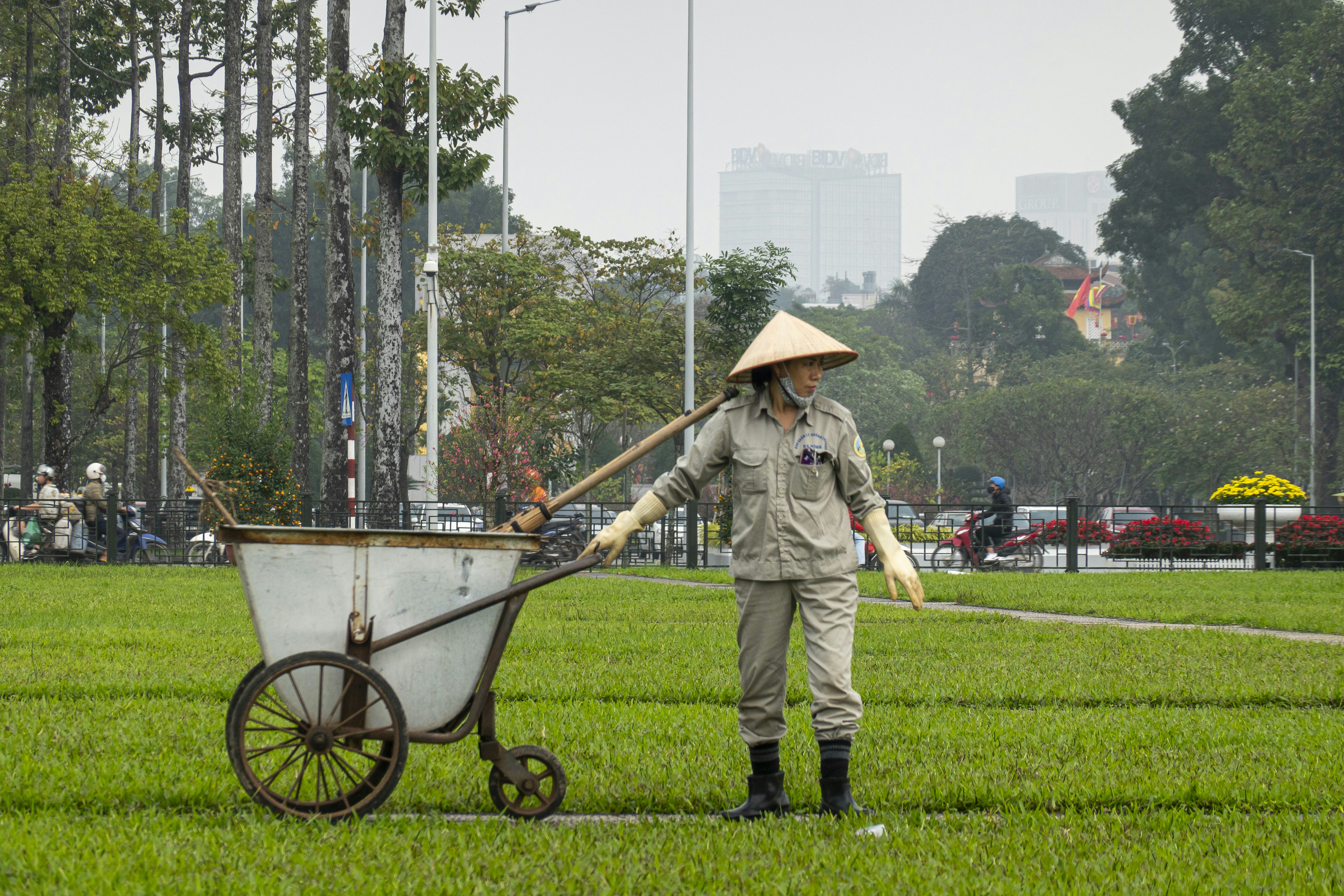 A woman pushing a wheelbarrow in a park