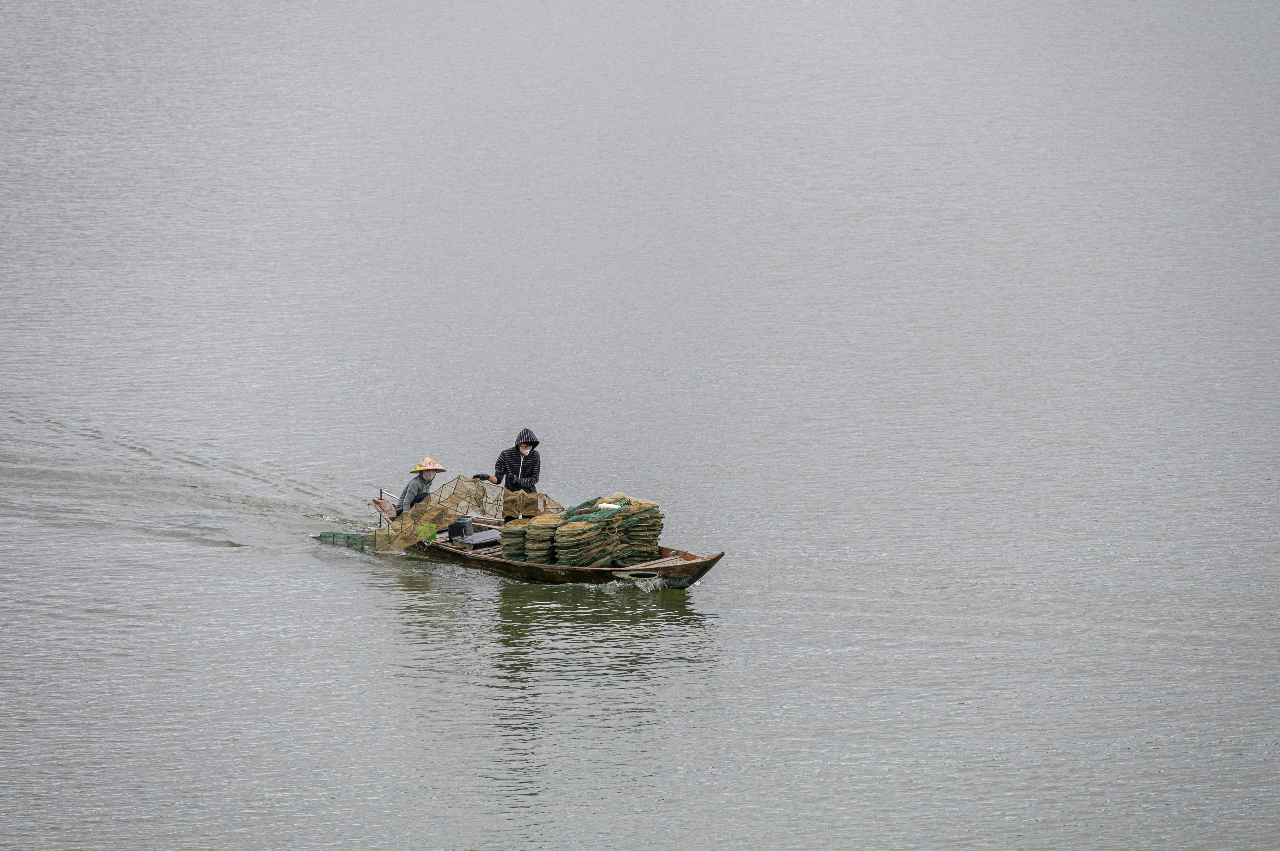 Two people in a small boat in the middle of a lake