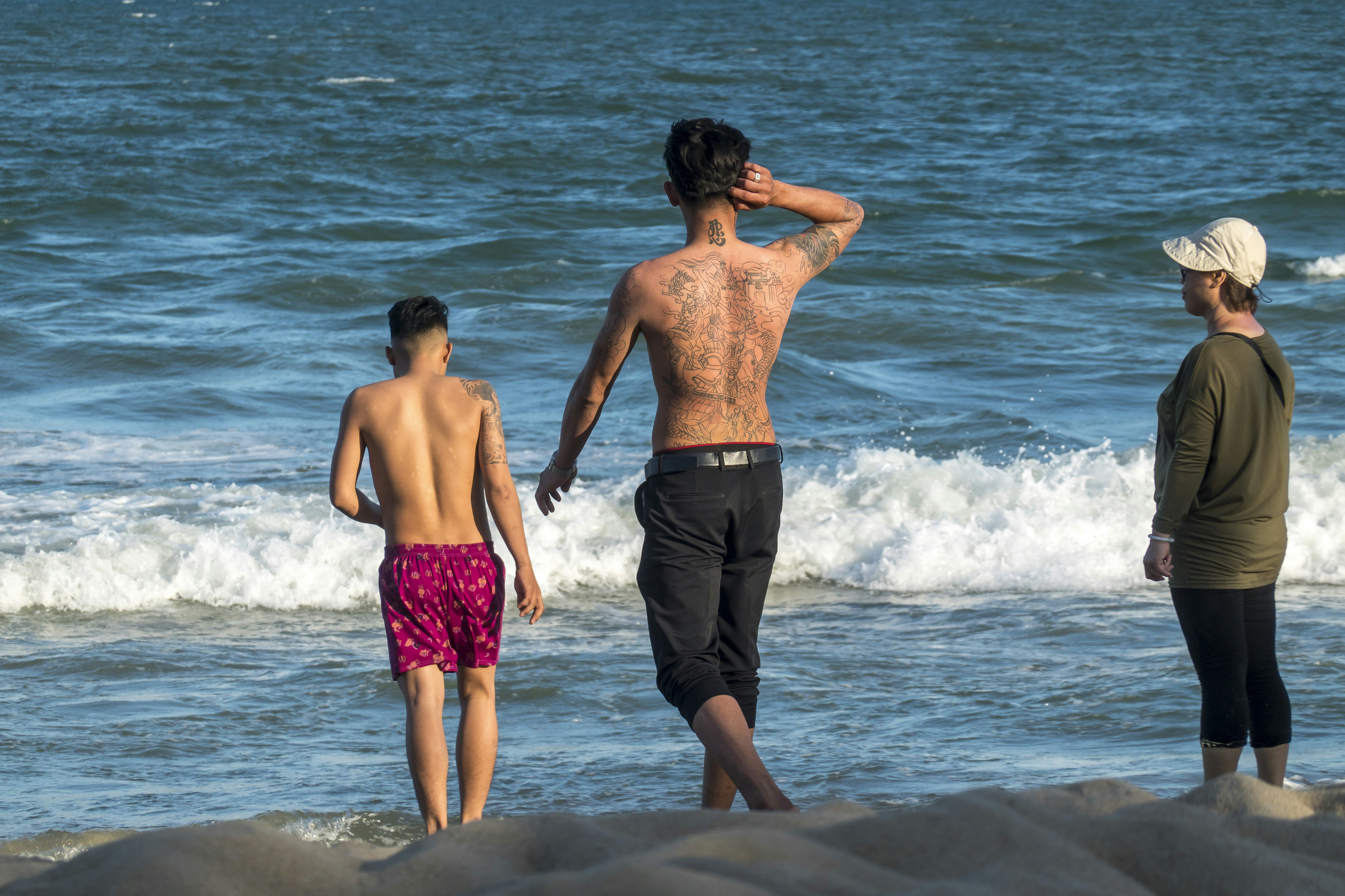 A group of people standing on top of a sandy beach