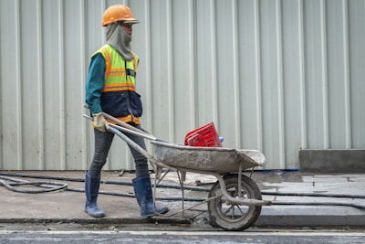 A construction worker pushing a wheelbarrow