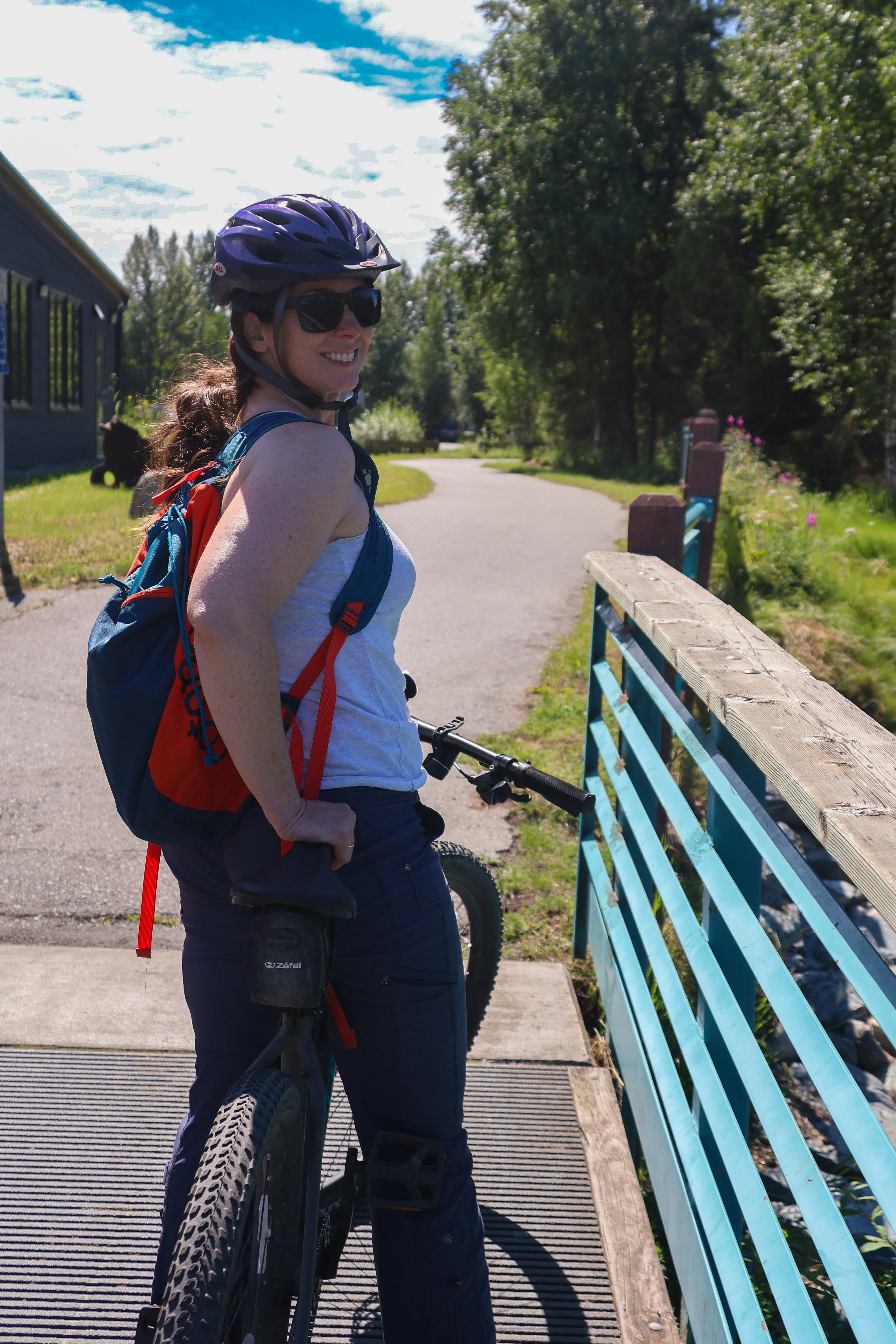 A woman riding a bike on a bridge