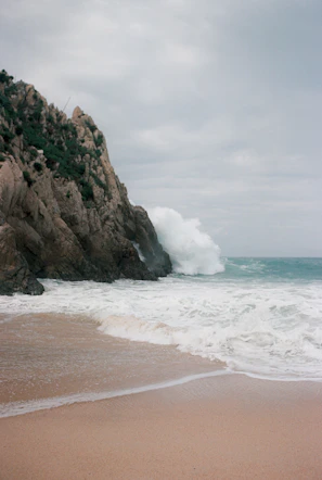 A beach with a wave coming in to the shore