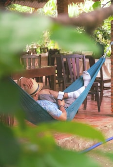 A man laying in a hammock on a patio