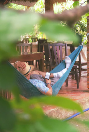 A man laying in a hammock on a patio