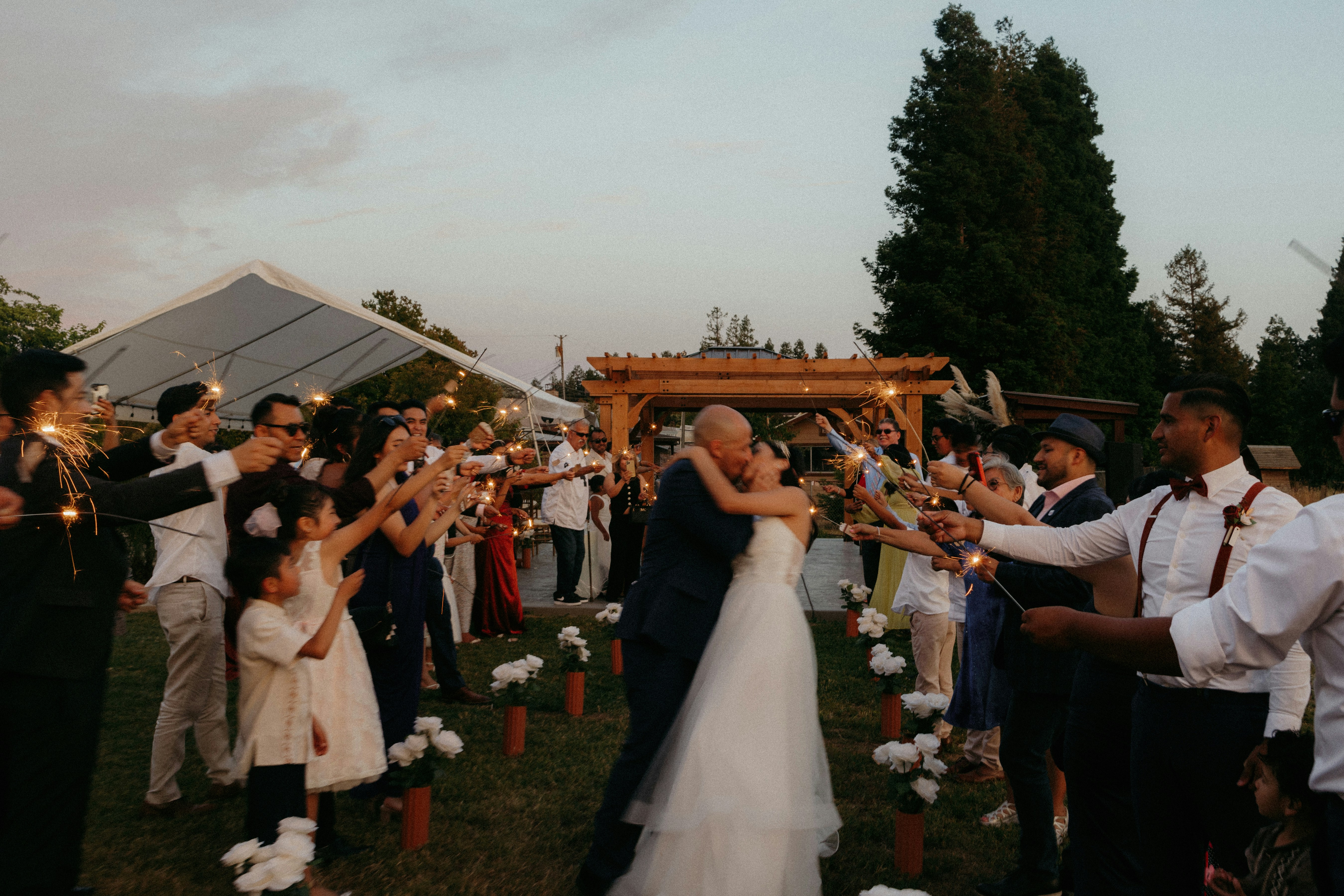 A bride and groom are surrounded by their guests
