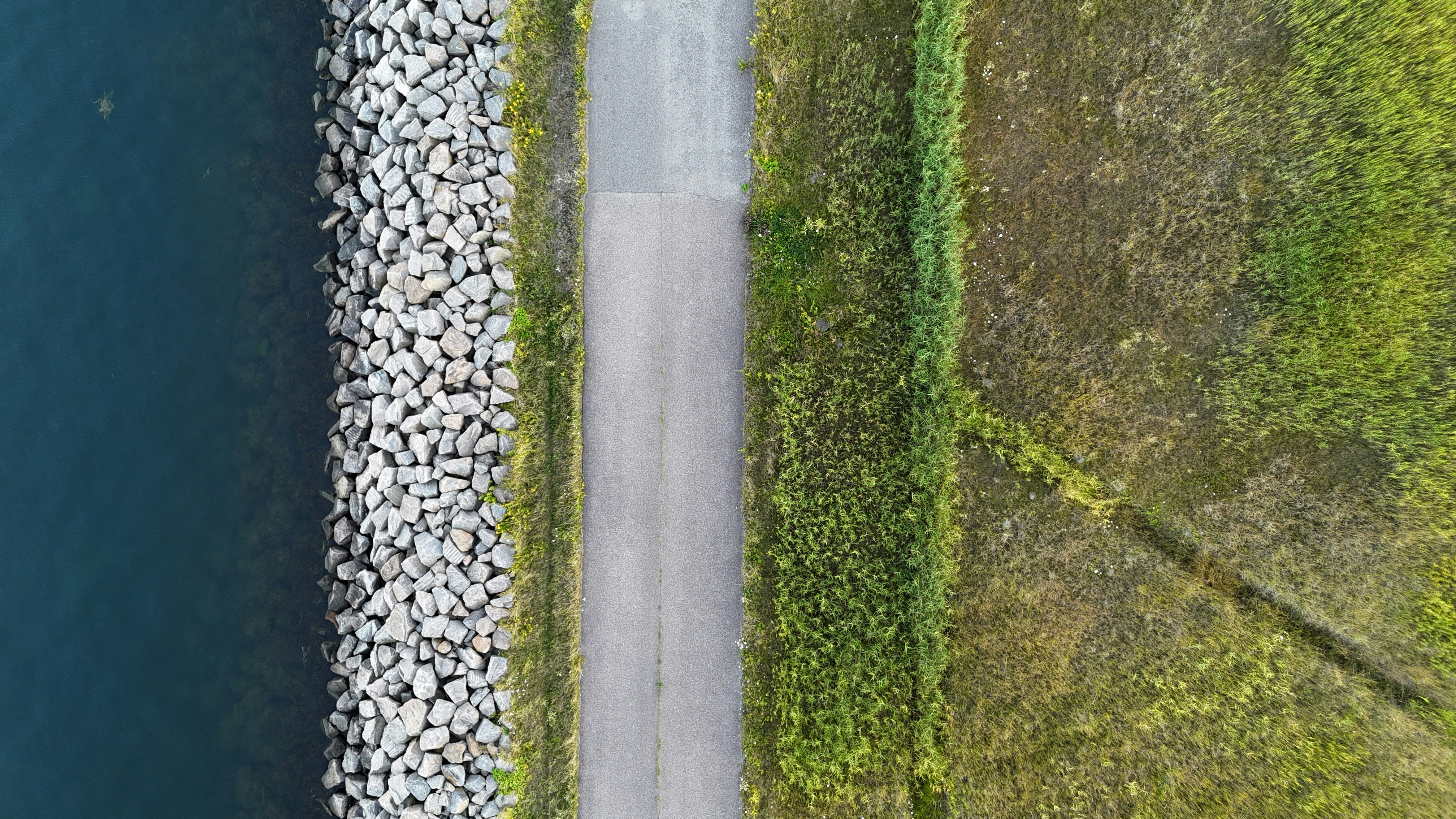 An aerial view of a road next to a body of water