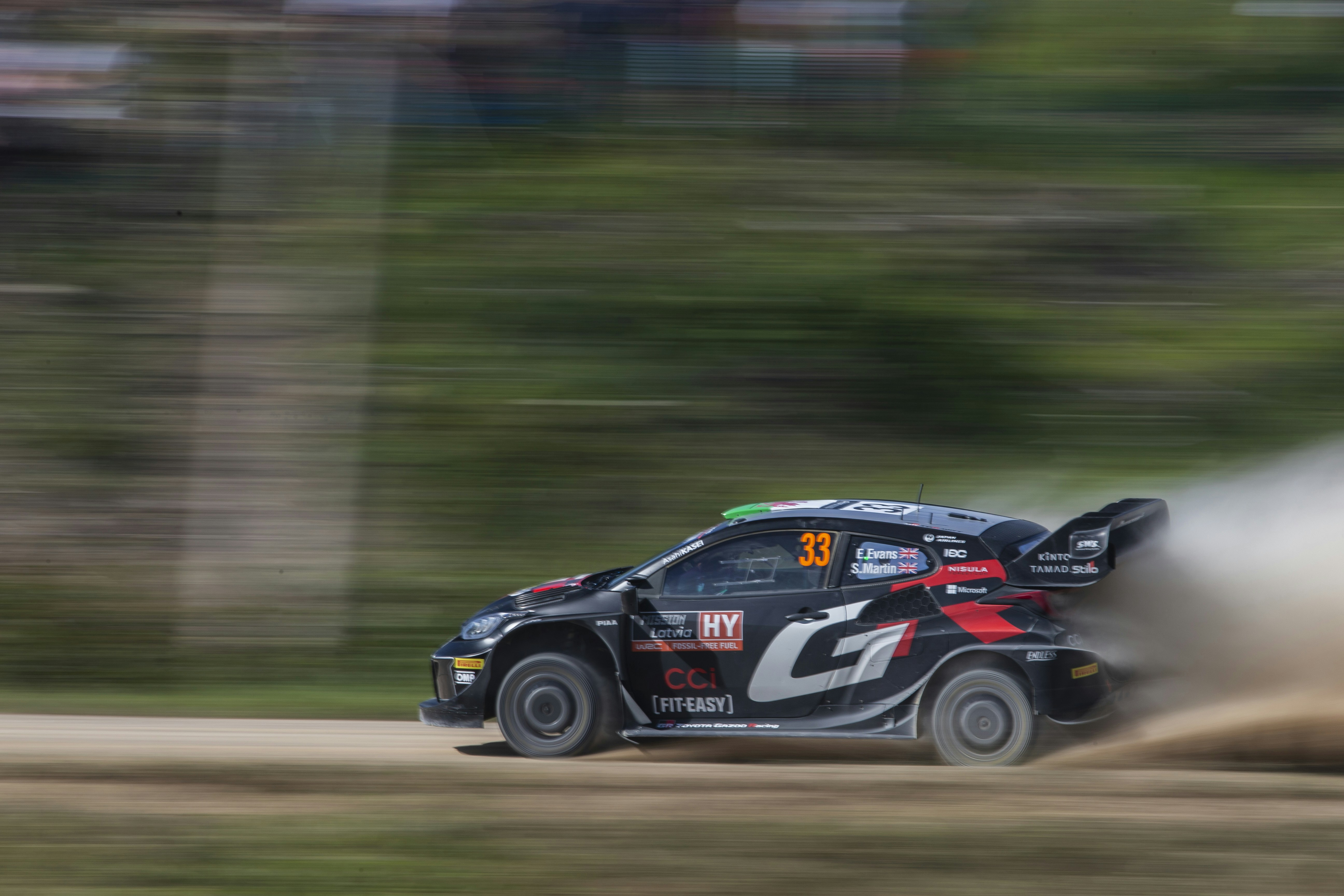 A car driving down a dirt road with a lot of dust coming out of it