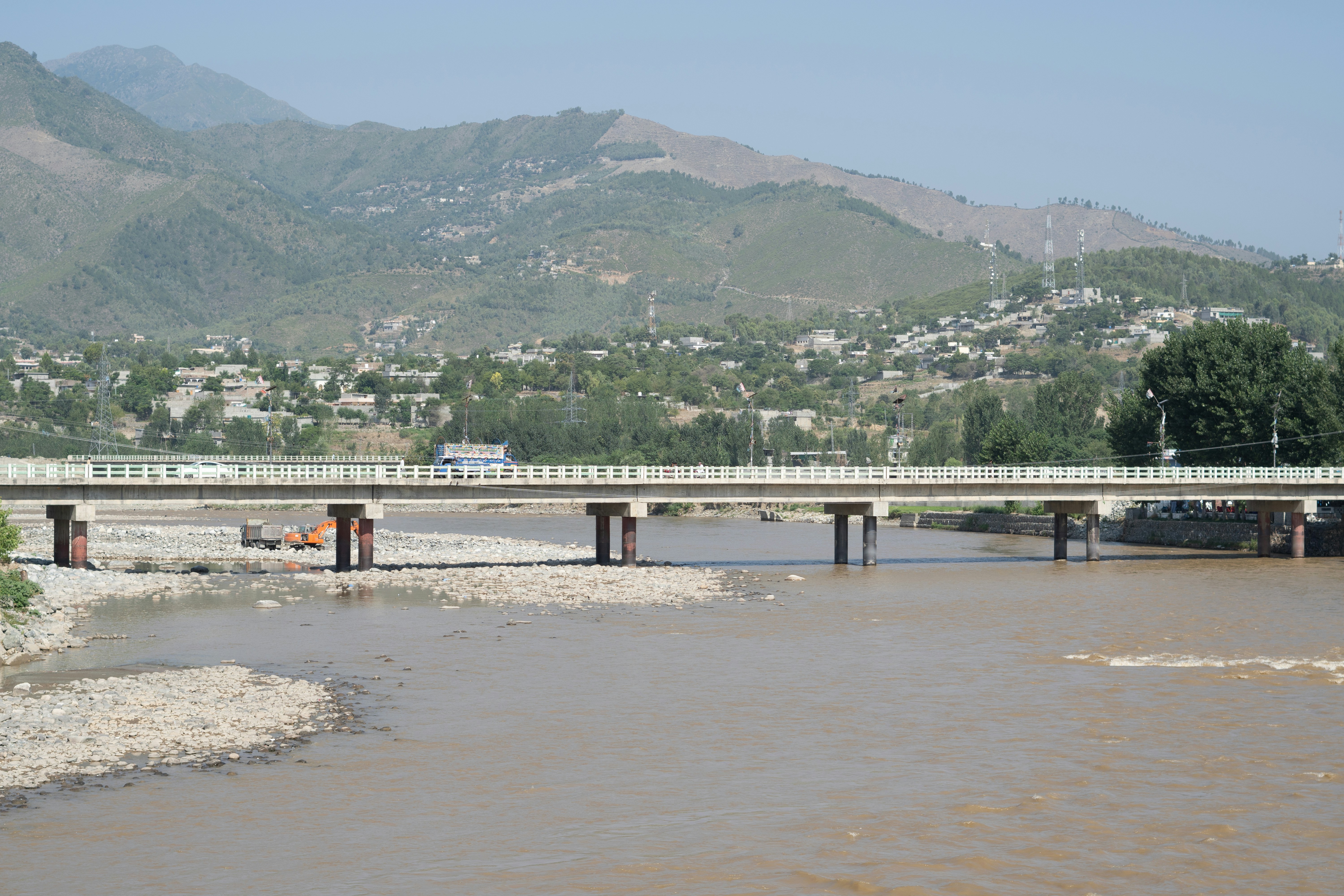 A bridge over a river with mountains in the background
