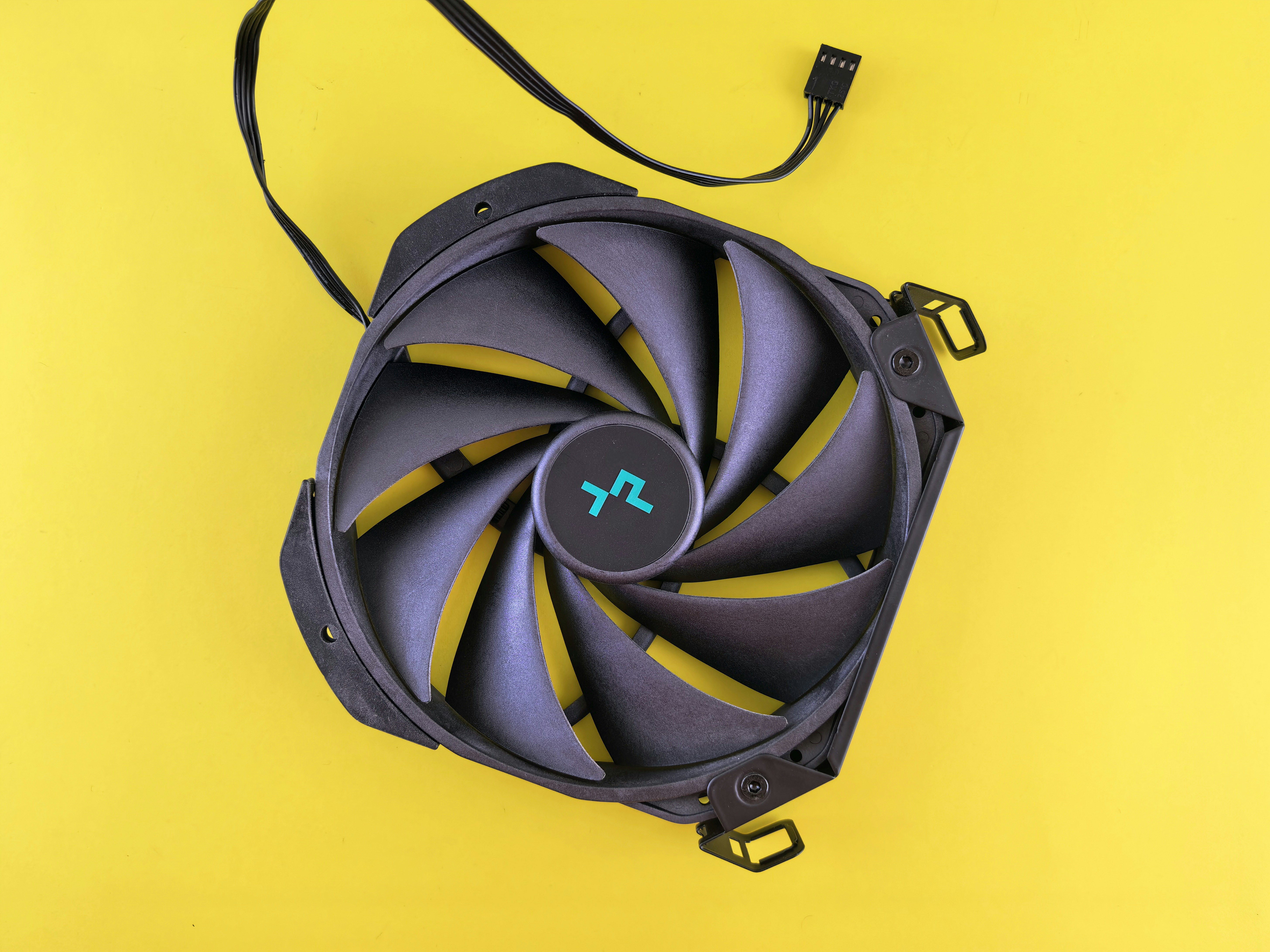 A computer fan sitting on top of a yellow surface