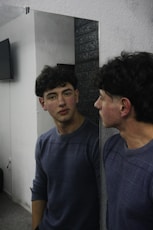 Two young men standing in front of a mirror