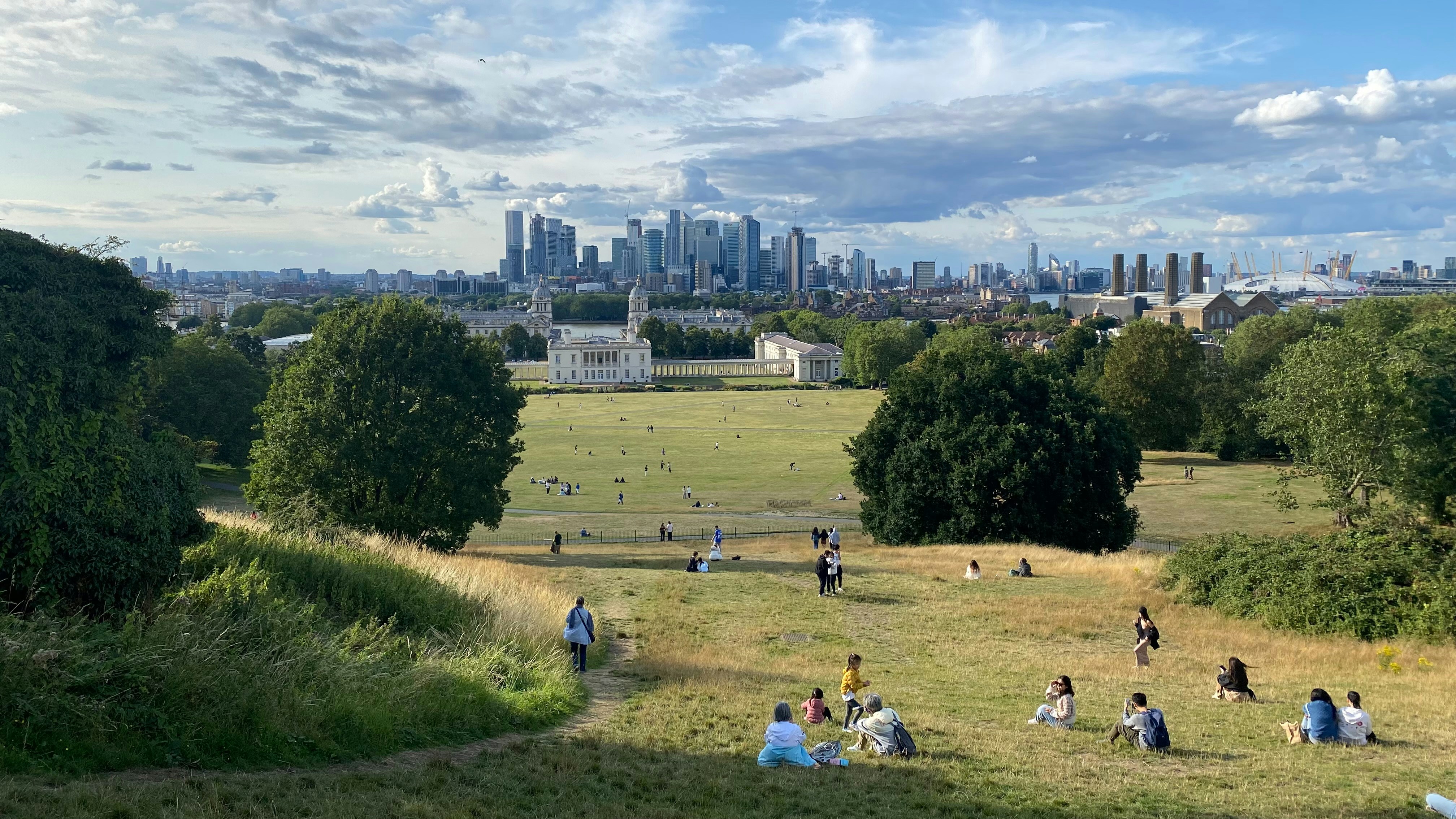 A group of people sitting on top of a lush green field