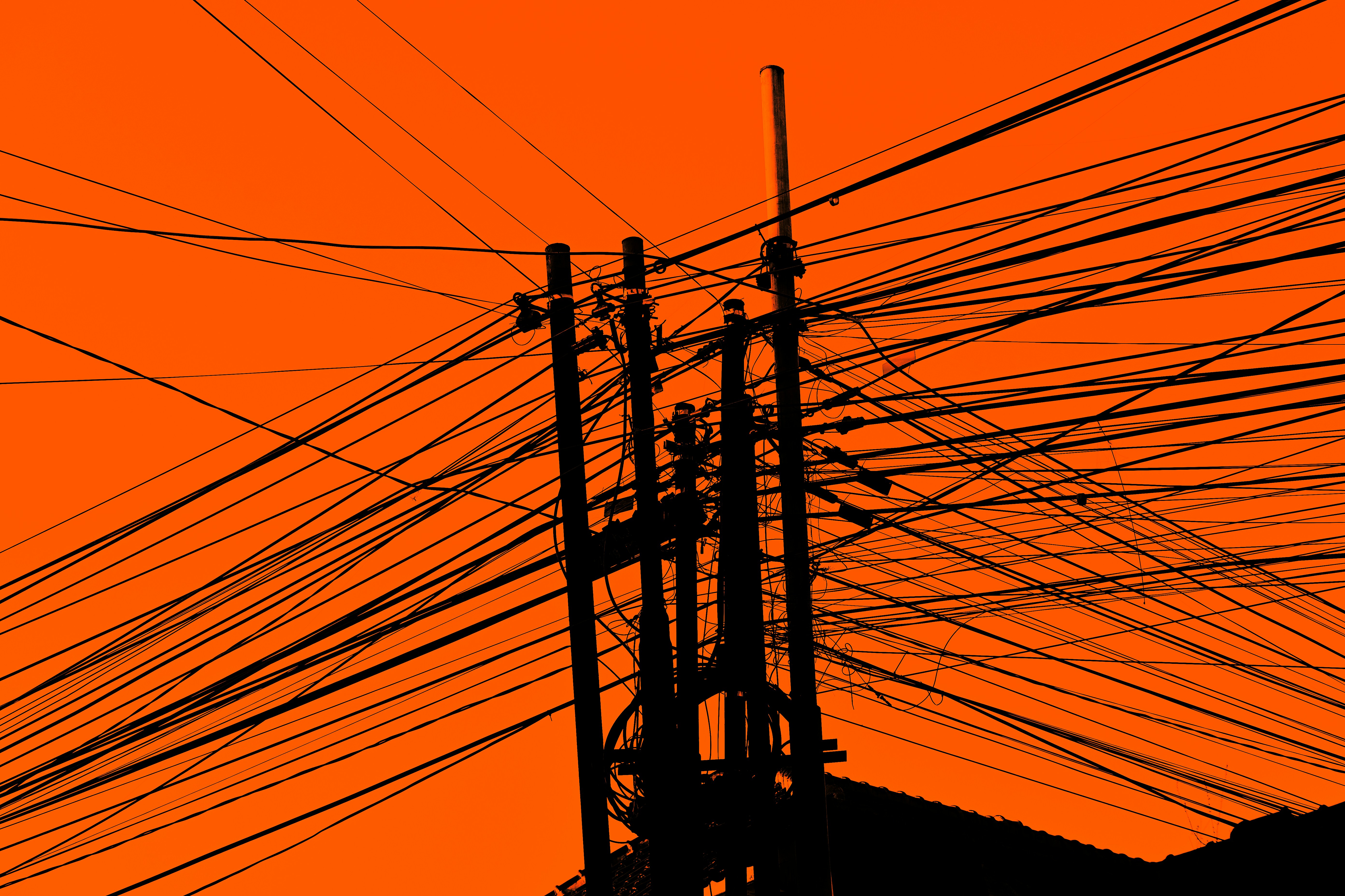 An orange sky with lots of power lines