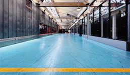 A large room with a blue floor and a yellow line