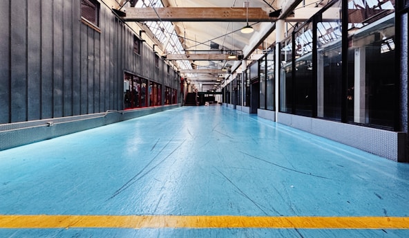 A large room with a blue floor and a yellow line
