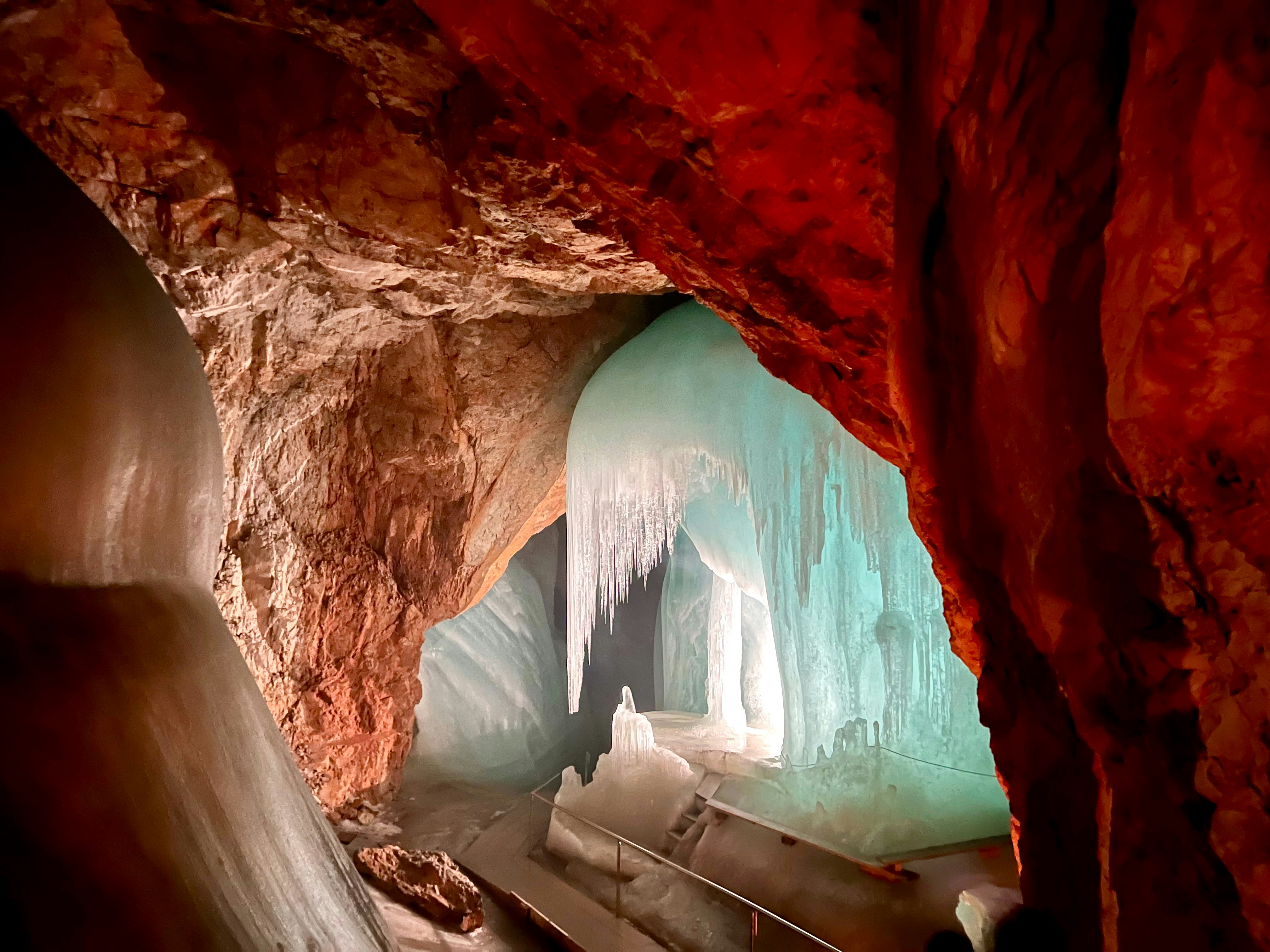 A man standing inside of a cave filled with ice