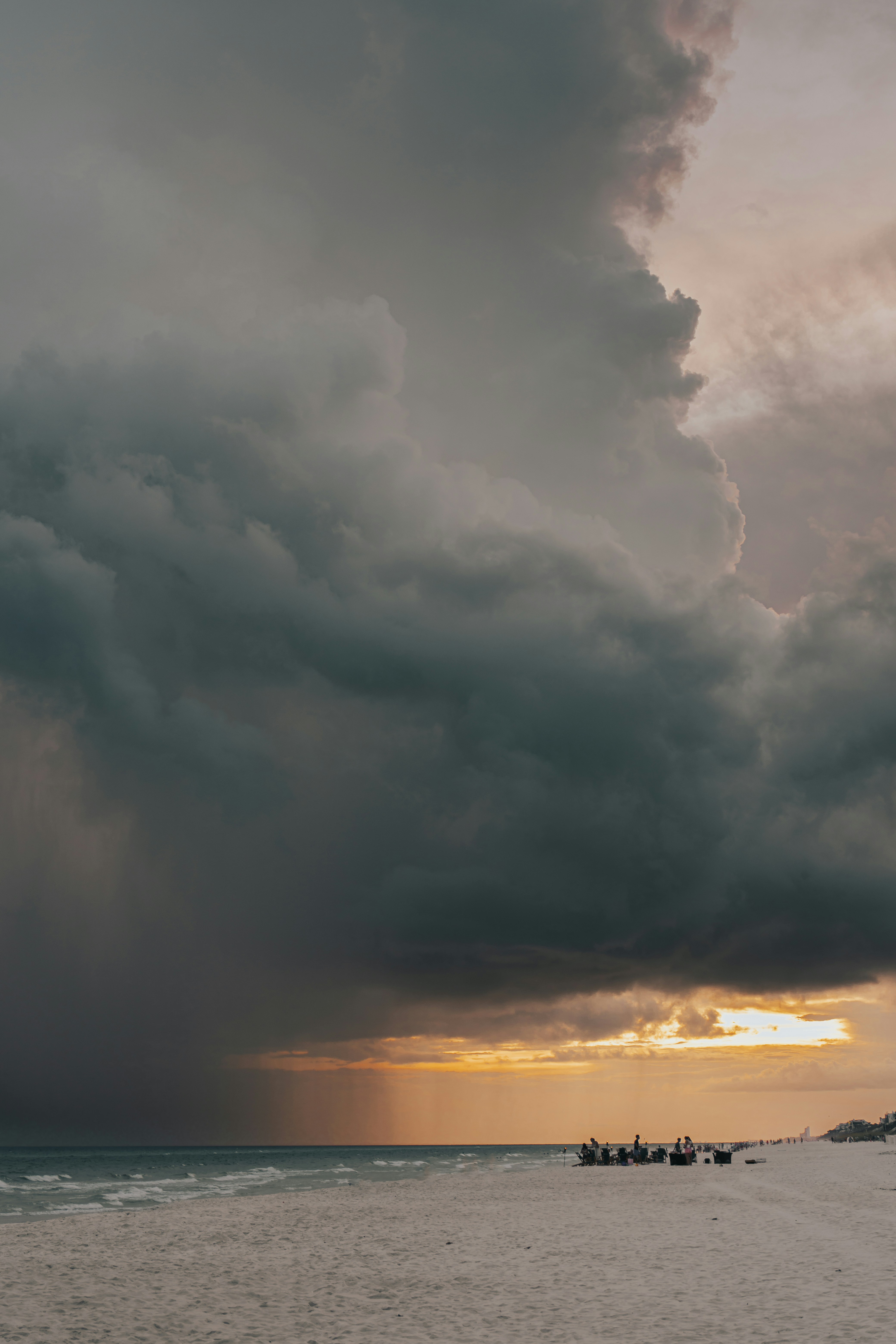 A group of boats sitting on top of a beach under a cloudy sky