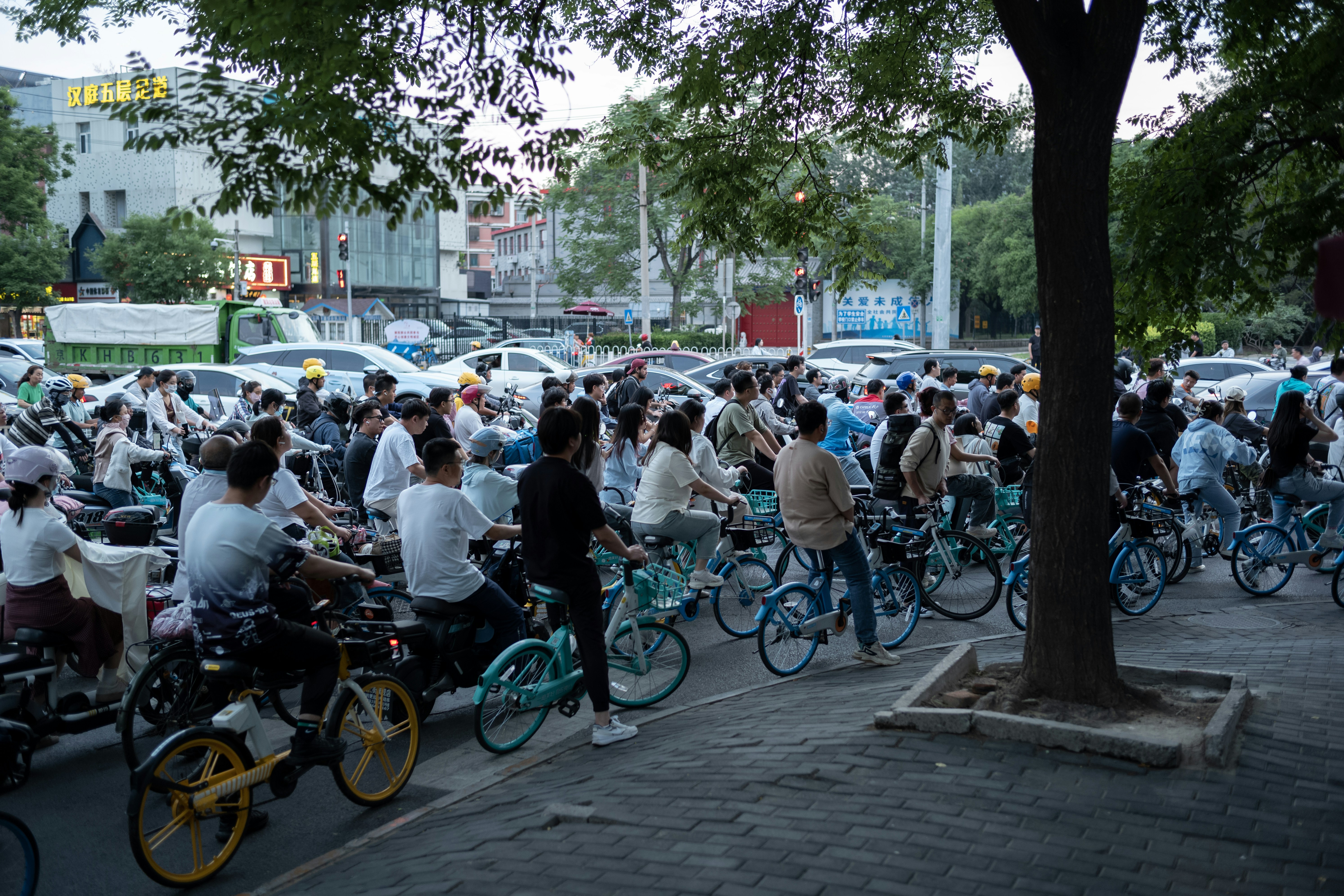 A large group of people riding bikes down a street