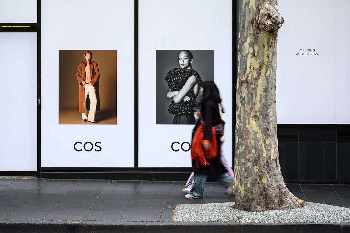A pedestrian walking through a leafy Melbourne CBD street