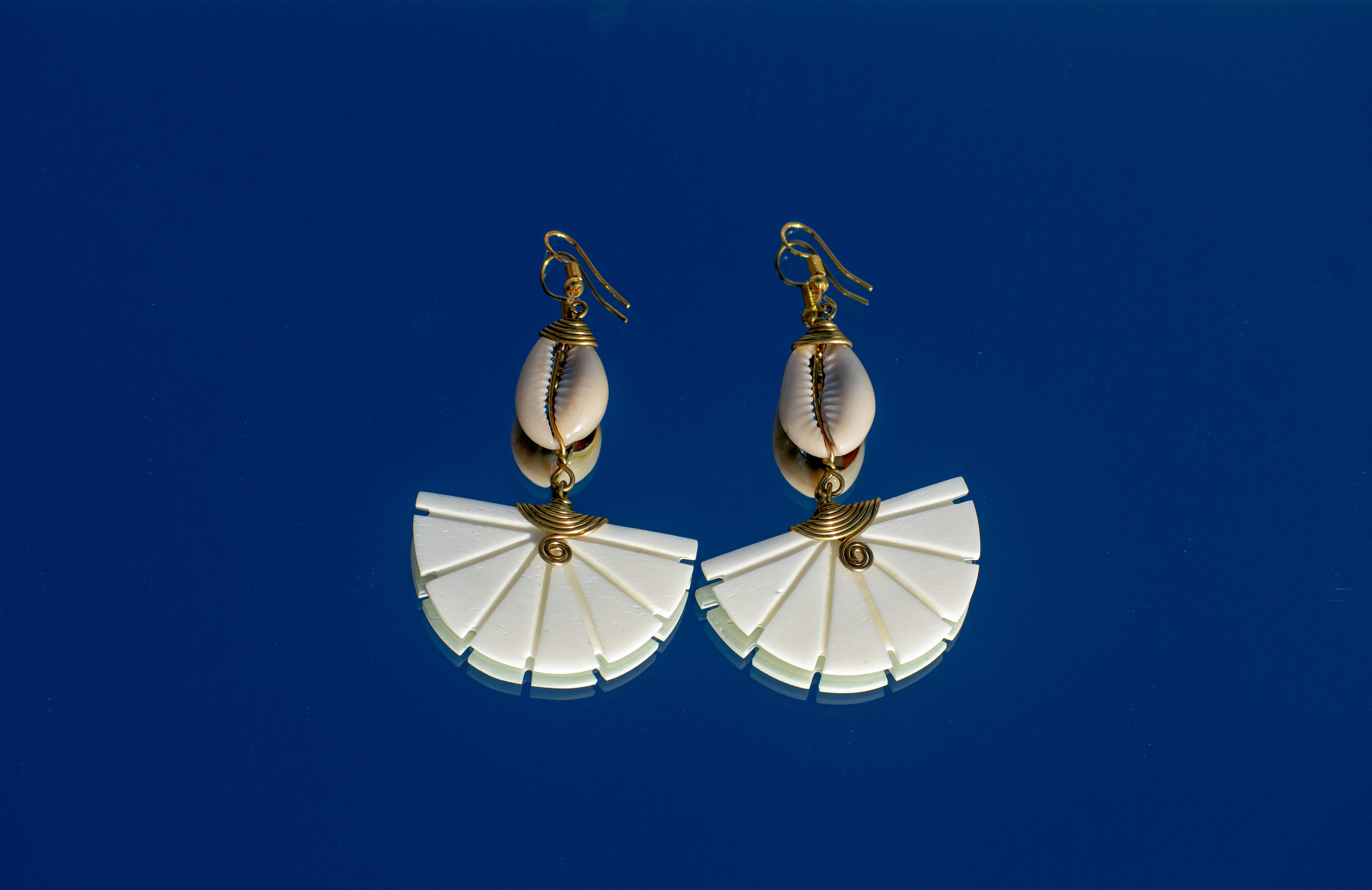 Un paio di orecchini bianchi a forma di ombrello contro un cielo blu