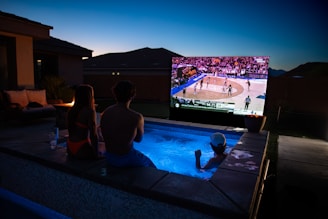 A group of people watching a game on a big screen TV