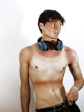 A man with no shirt wearing headphones