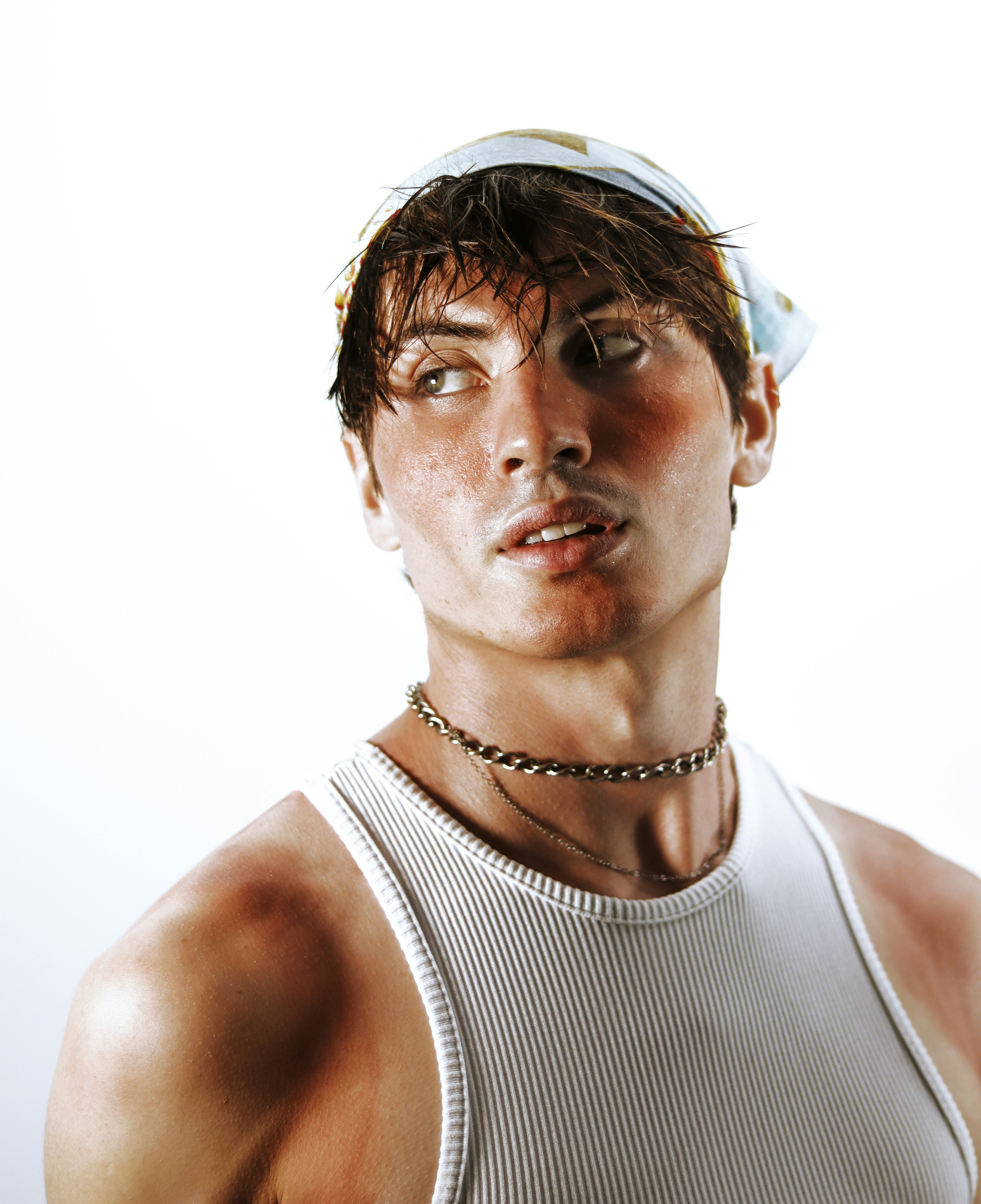 A man in a white tank top making a funny face